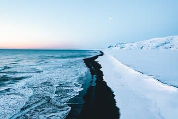 Reynisfjara Black Sand Beach lies along the coast covered by snow during winter.
