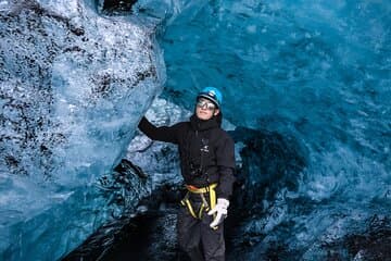 A man explores an ice cave in Iceland.