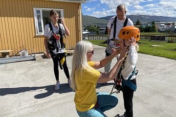 Staff member securing guests in safety gear.