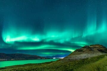 Spectacular aurora display over a fjord