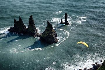 On a good day you can paeraglide above the famous sea stacks Reynisdrangar