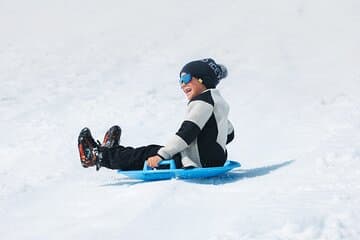 Sledding down a slope on the glacier