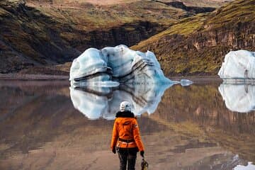 We walk past the glacier lagoon in front of Sólheimajökull, where icebergs float and showcase their layers of black volcanic ash from previous eruptions